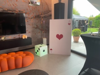 Décoration sur le thème du casino avec une grande carte as de cœur et un luminaire en forme de dé.